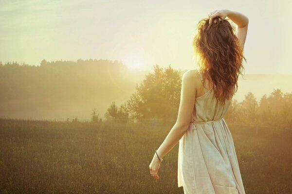 A girl admires a foggy morning