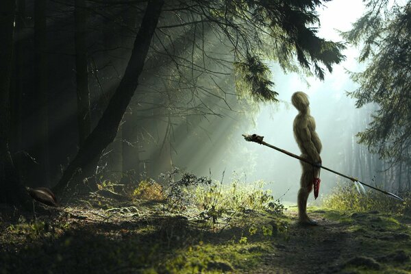 Krieger mit Speer im grünen Wald in der Sonne