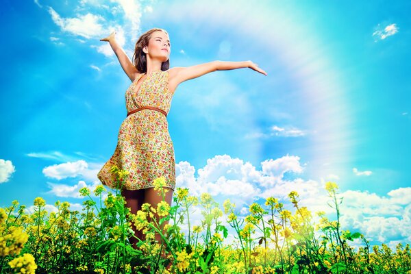 Ragazza in campo con fiori su sfondo arcobaleno