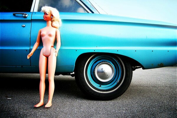 Doll on the background of a blue car