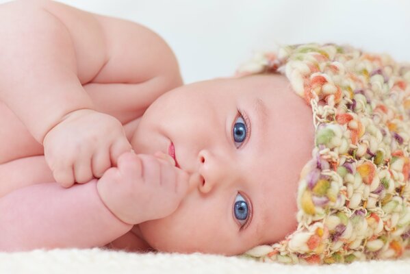 Bambino con gli occhi azzurri in un cappello colorato