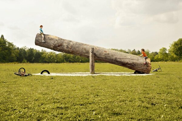 Los niños se balancean en un tronco como un columpio