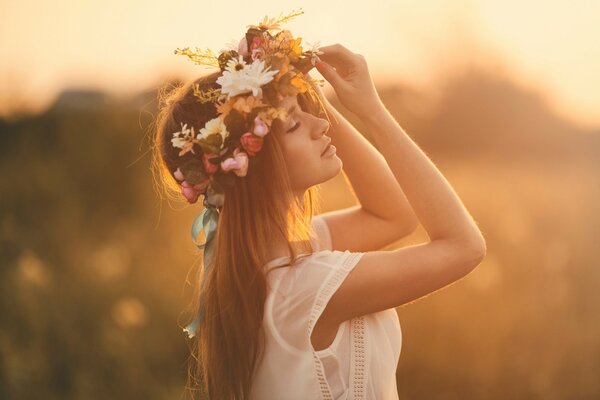 Giovane vergine in una corona di fiori estivi