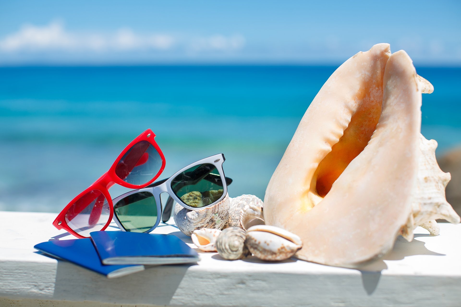sommer urlaub strand zubehör brille sonne muscheln blauer himmel meer