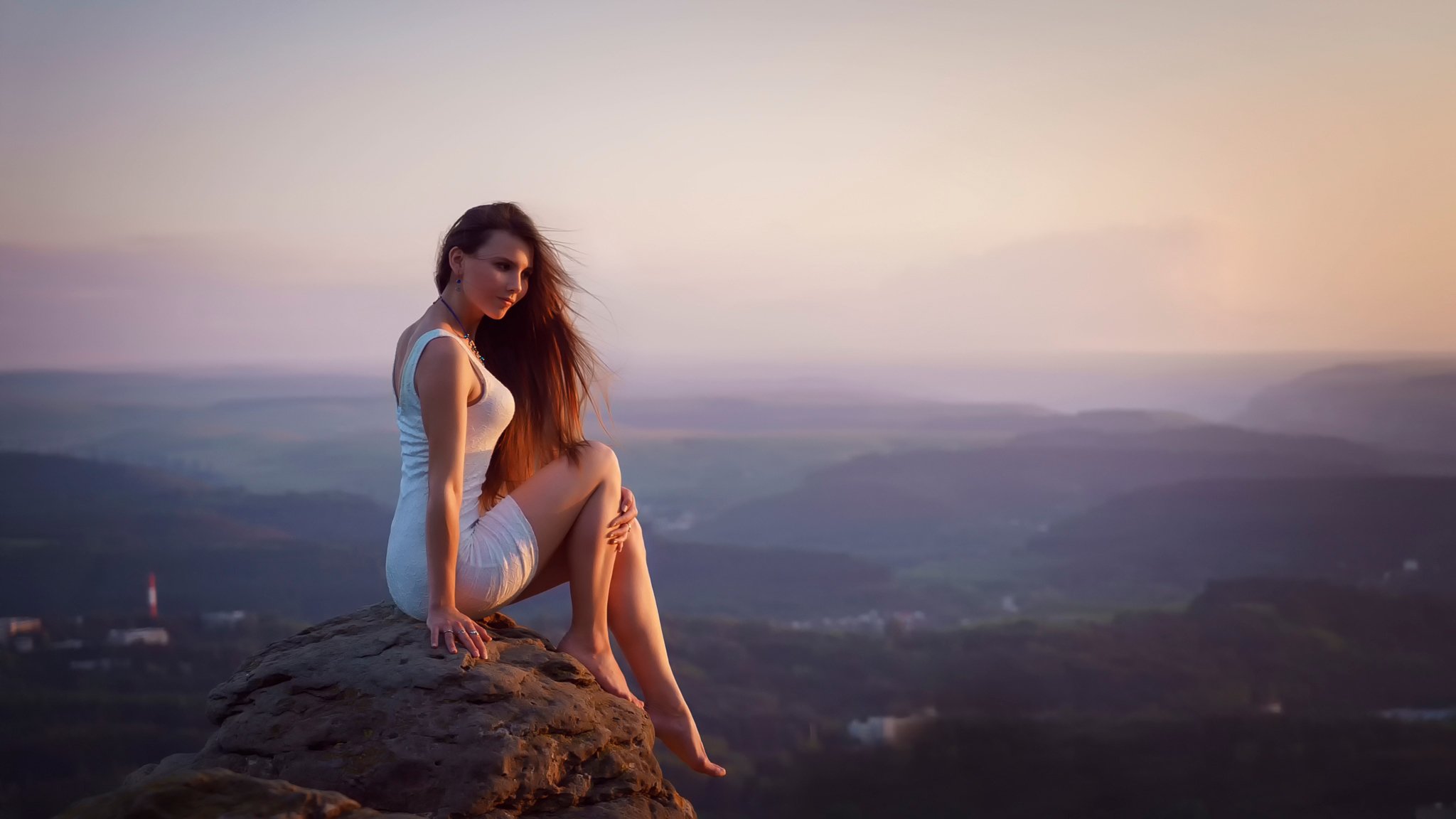 la jeune fille la robe la pierre les pieds la hauteur la vue le coucher de soleil