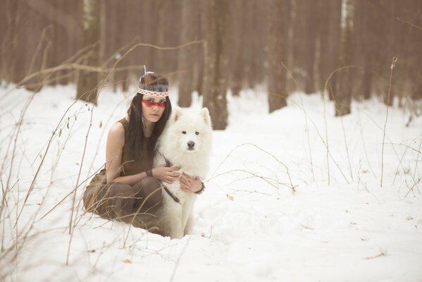 A girl with a dog in a winter forest