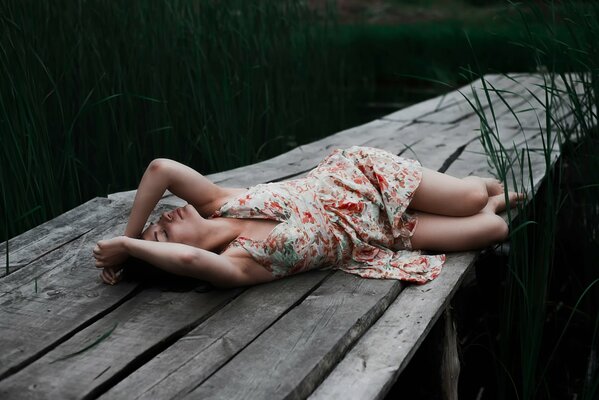 Ragazza che riposa sul ponte sul fiume