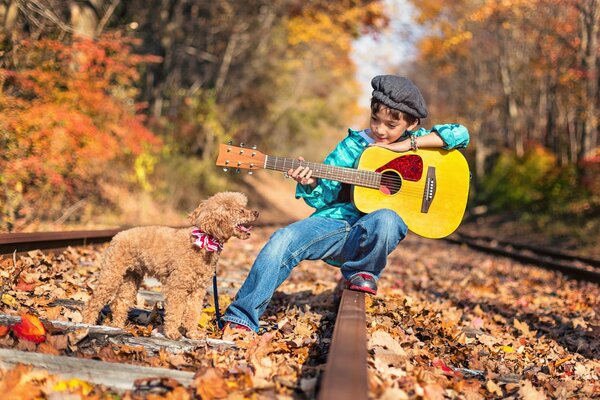 A boy with a poodle and a yellow guitar