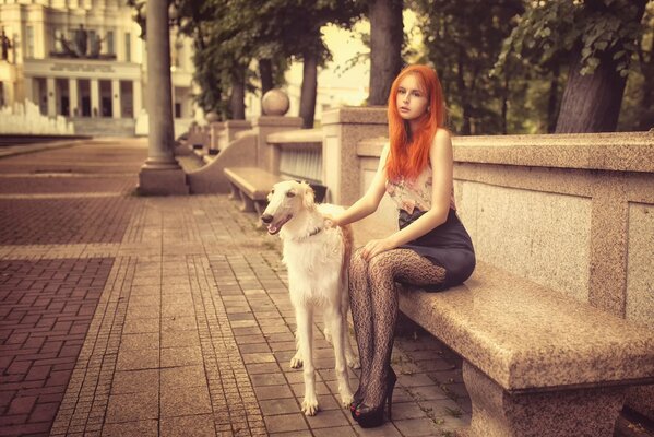 Ragazza dai Capelli rossi sulla panchina con il cane