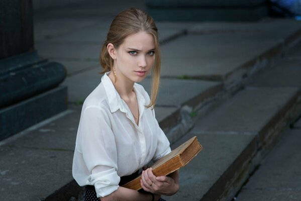 Ernstes Mädchen mit einem Buch in der Hand
