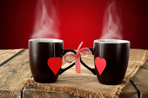 Black cups with hearts on a rustic background