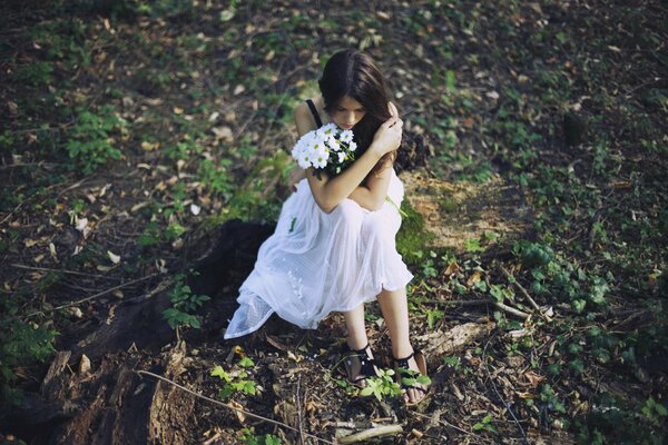Ragazza in abito bianco nella foresta