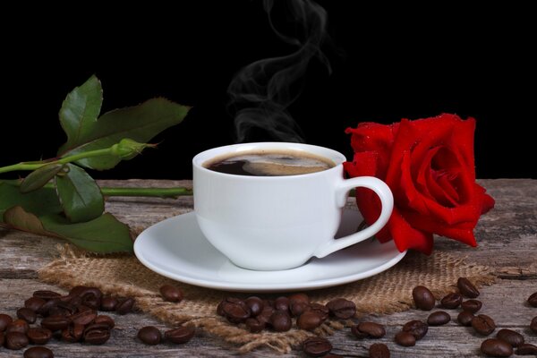 Tazza di caffè profumato sul tavolo con rosa rossa