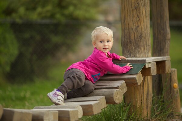 Niño pequeño jugando en una escalera de madera