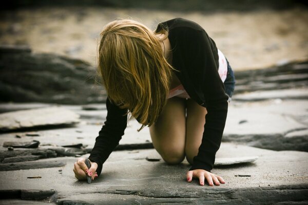 La ragazza scrive con il gesso sulla pietra