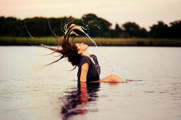Brunette sur le lac agite ses cheveux