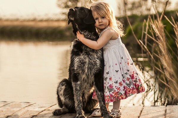 Mädchen mit Hund spazieren in der Nähe des Flusses