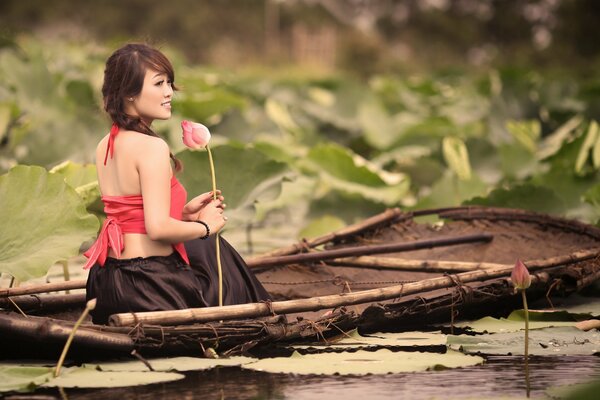 Fille nage sur un bateau et tenant une fleur