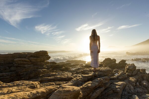 Chica en un vestido con un cuerpo elegante posando en el sol