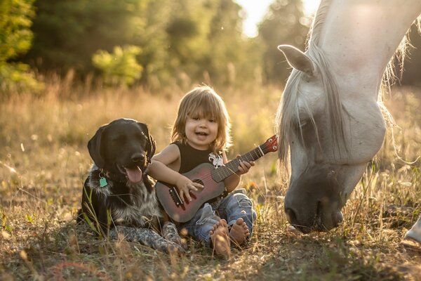 Niño con guitarra con amigos perro y caballo