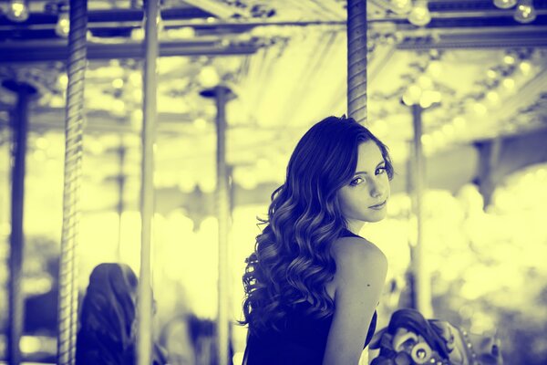 Black and white photo of a girl on a carousel