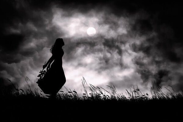 Black silhouette of a girl on the background of a full moon