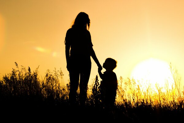A girl with a boy in a field at sunset