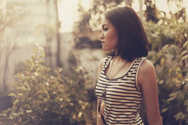 Brunette with a feather pendant looks into the distance