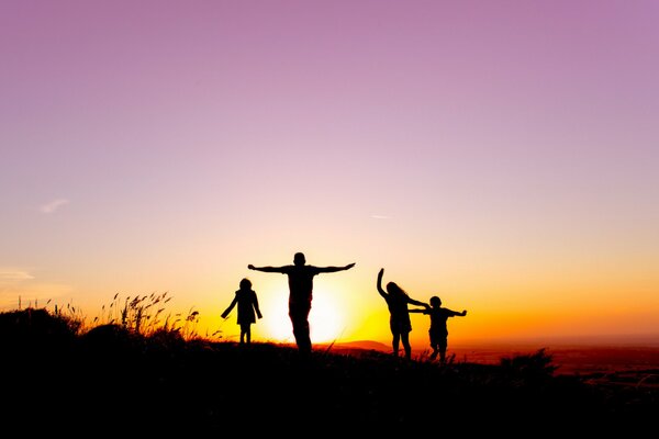 Sagome di persone sullo sfondo del tramonto
