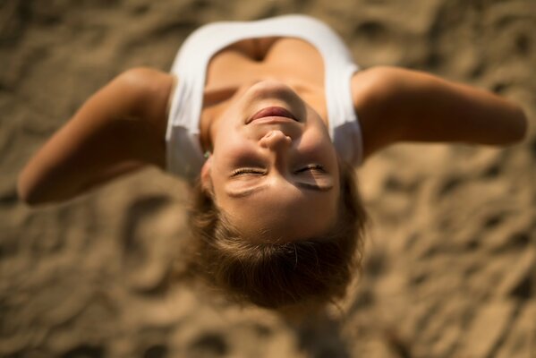 The girl smiles with her head back into the sun