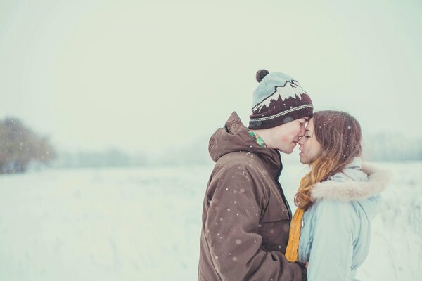 Le gars et la fille tendrement enlacés au milieu de la neige