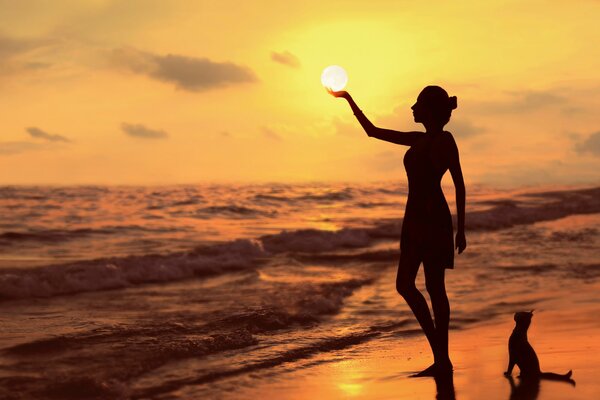 The sun on the palm of a girl on the shore