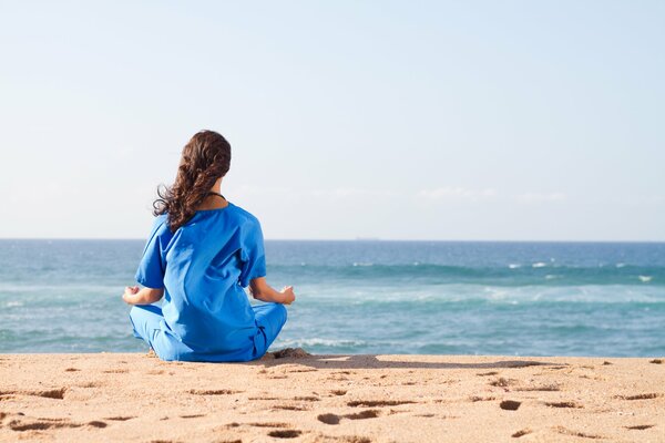 Mädchen entspannt sich mit yoga am Meer