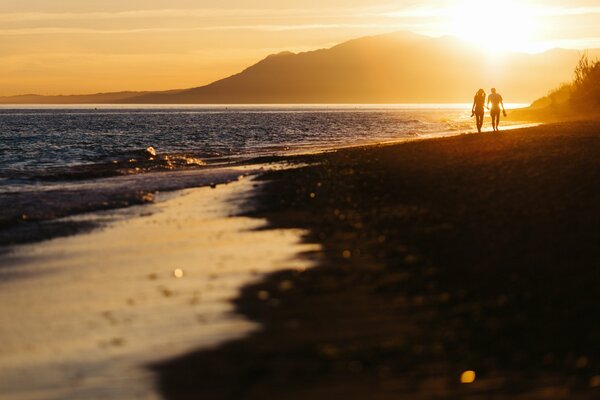 Dos amantes se encuentran con la puesta de sol en la playa