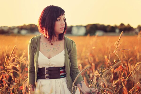 Foto di una giovane ragazza in un campo al tramonto