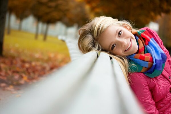 Chica alegre en el banco del parque
