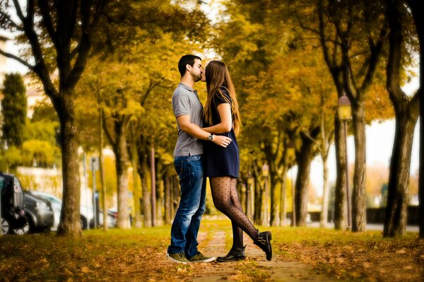 Couple kissing in the alley in autumn