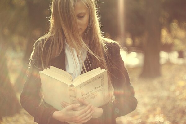 A girl is reading a thick book