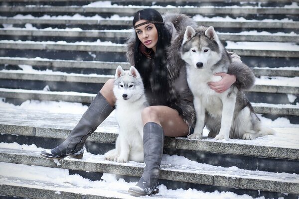 Huskies and a girl on a winter background