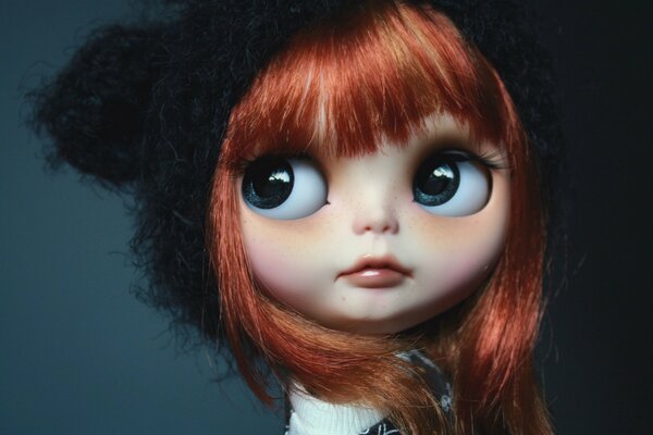 A red-haired doll in a hat with big eyes