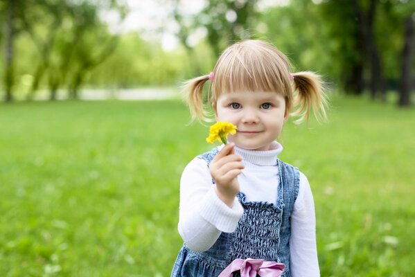 Cute little girl with a flower in the park