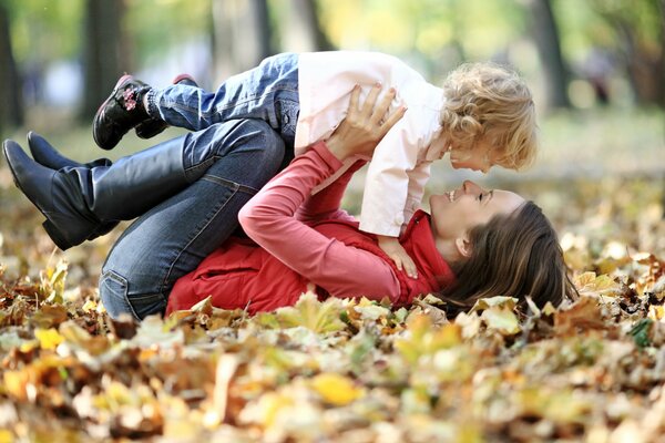 A girl with a child playing in the foliage