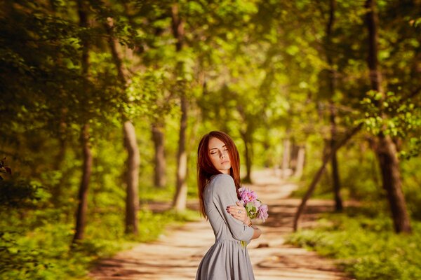 A girl in an alley with flowers in her hands