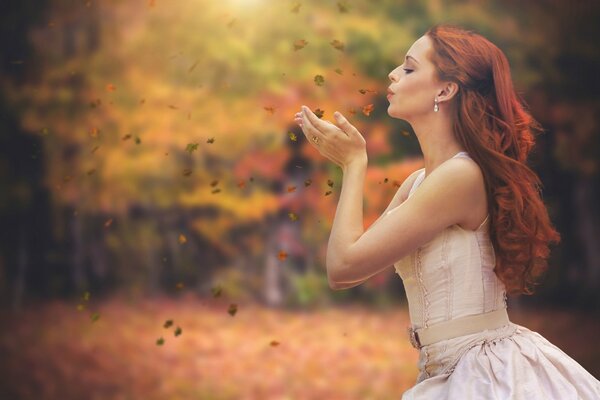 Pelirroja chica con hojas de otoño