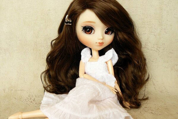 A doll with long hair in a white dress