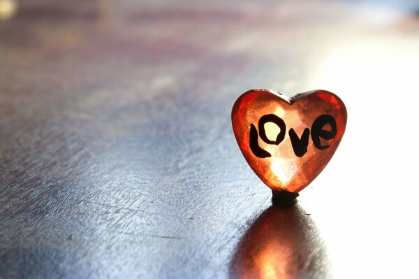 Corazón con letras de amor en la mesa de madera