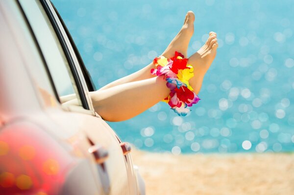 Gambe femminili da automlbil sulla spiaggia