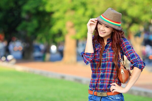 Ragazza asiatica in un cappello nel parco