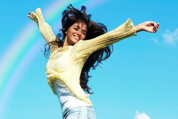 Chica disfruta del arco iris en el cielo