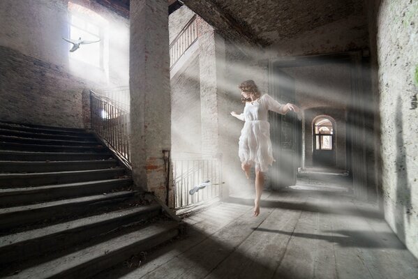 An abandoned house and a dancing girl in a white dress